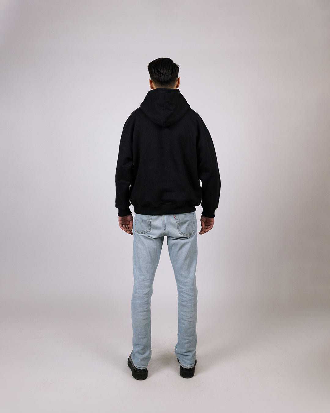 Essential Hoodie Black - Relaxed Fit, back view, comfortable cotton-polyester blend.